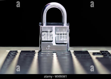 Computer Security Concept with a Closed Padlock on the Keyboard on Black Background Stock Photo