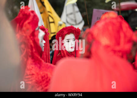 London, UK. 17th September, 2019. Extinction Rebellion staging a protest at the London Fashion Week, here seen are the creative and imaginative red robes and white faces of the Red Rebel Brigade outside the fashion venue. Credit: Joe Kuis / Alamy News Stock Photo