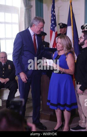New York, New York, USA. 17th Sep, 2019. Mayor De Blasio along with Actor/9/11 Activist Jon Stewart and Feel Good Foundation President John Feal honor family of 9/11 First Responder Luis Alvarez with Key To the City on September 17, 2019 at City Hall in the Governors Room in New York City. Credit: Mpi43/Media Punch/Alamy Live News Stock Photo