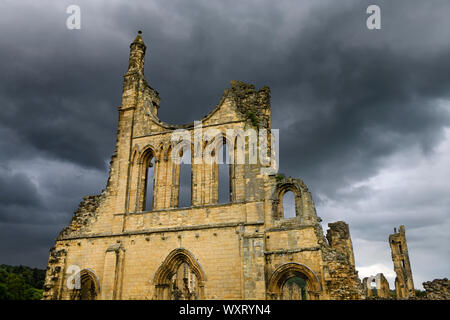 Ruins of 12th Century Byland Abbey in North Yorkshire England North York Moors National Park under dark clouds at sunset Stock Photo