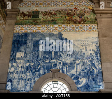 Decorative ceramic tiles surround the interior of the entrance hall of the railway station in Porto Stock Photo