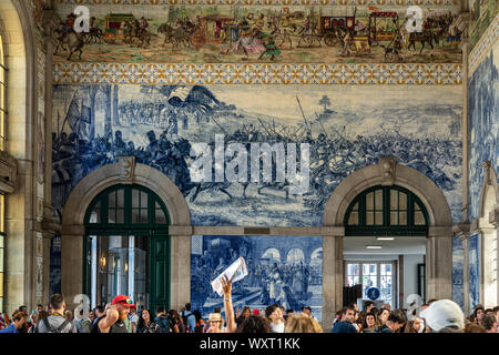 Decorative ceramic tiles surround the interior of the entrance hall of the railway station in Porto Stock Photo