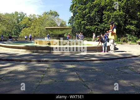 People outside enjoying the Italian Cultural Garden in Rockefeller Park in Cleveland, Ohio, USA with its large renaissance fountain. Stock Photo