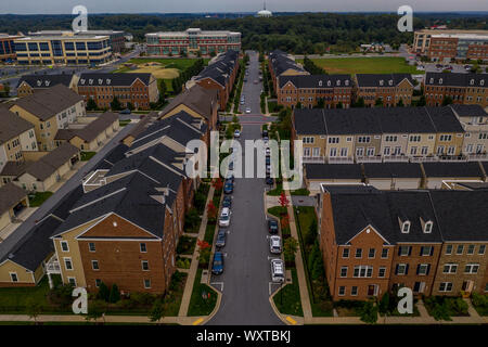 American real estate neighborhood street in Maryland with typical east coast brick facade townhouses with blue cloudy sky aerial view Stock Photo