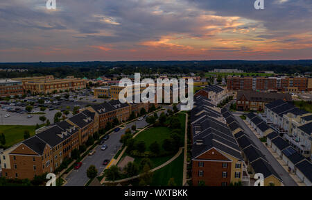 American real estate neighborhood street in Maryland with typical east coast brick facade townhouses with blue cloudy sky aerial view Stock Photo