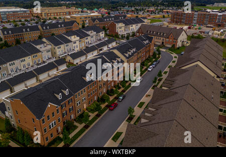 American real estate neighborhood street in Maryland with typical east coast brick facade townhouses with blue cloudy sky aerial view Stock Photo