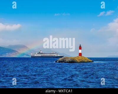 View of  Les Eclaireurs (the scouts) Lighthouse in the Beagle Channel near Ushuaia, Argentina, with a cruise ship and rainbow in the background Stock Photo