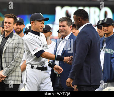 Seattle Mariners legends Edgar Martinez, left, and Ken Griffey Jr., right,  pose for a photo after they raised a flag for the 2023 MLB All-Star Game on  the roof of the Space