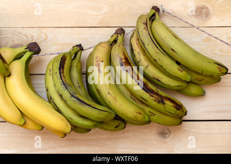 Street fruit market, fresh bananas hanging on a wooden board. Image Stock Photo