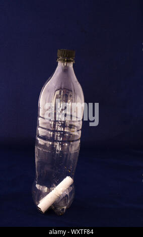 A rolled up piece of paper in a closed bottle isolated on a dark background  image with copy space in vertical format Stock Photo