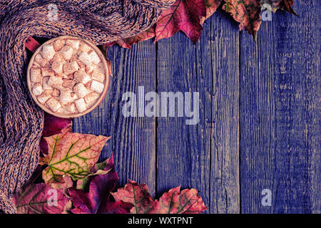 Autumn background with hot chocolate, knitted scarf, multi-colored leaves. Top view with copy space. Stock Photo