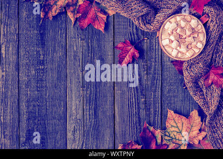 Autumn background with hot chocolate, knitted scarf, multi-colored leaves. Top view with copy space. Stock Photo