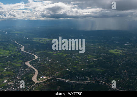 Pouring rain from low altitude Cumulonimbus clouds above Lamphun province of Thailand Stock Photo