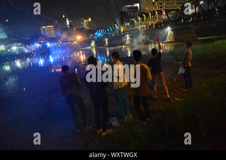 A group of local boys hanging out in the city center of Chiang Mai and watching the fireworks during the celebration of the annual Loi Krathong festival.Ping River, city center, Chiang Mai, Chiang Mai Province, northern Thailand, Thailand, Southeast Asia, Asia Stock Photo
