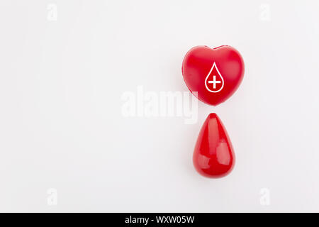 Giving blood saves live. Blood Donation concept. Red heart and blood drop on white background Stock Photo