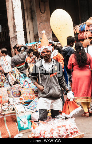 Kolkata, West Bengal, India 25th December, 2018 - A street hawker selling Christmas cap in the street of kolkata while nicely posing to the photograph Stock Photo