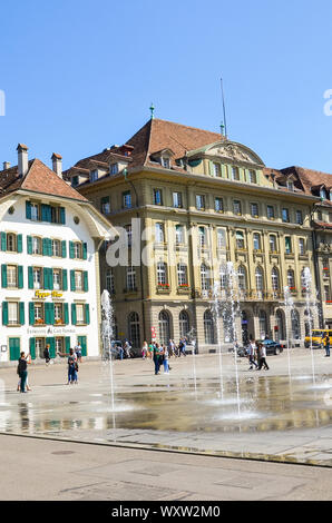 Bern, Switzerland - August 14, 2019: Bundesplatz, the square in the historical old town of the Swiss capital with people. Traditional buildings, cafes, restaurants. Water fountains. Sunny summer day. Stock Photo