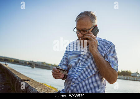 Outdoor portrait of senior man who is talking on phone. Stock Photo