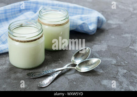 Greek Yogurt In A Glass Jars With Spoons On White Background Stock