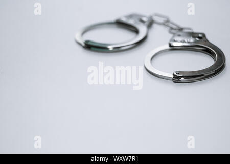 Handcuffs on a white background in the upper left corner of the frame. Stock Photo
