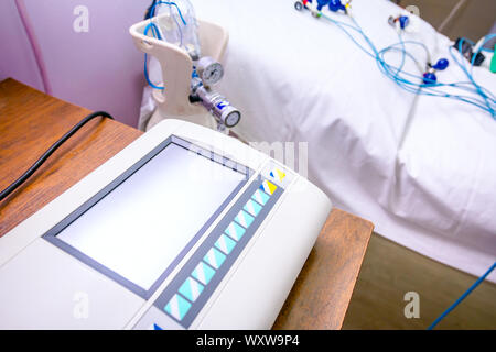 Modern machine with display for recording ECG or EKG over electrodes, sensors for electrocardiogram of patient's heartbeats. Stock Photo
