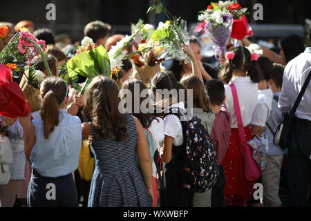 Children hold flowers in their first day of school Stock Photo