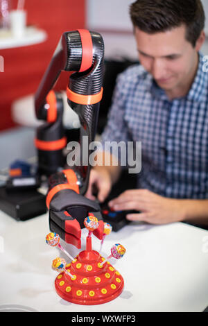 Duesseldorf, Germany. 18th Sep, 2019. Robot arm Bateo reaches for a lollipop. Bateo robot arm makes it possible for people with high paraplegia to grasp independently. The fair presents possibilities to lead a largely self-determined life despite disability with the help of innovative rehabilitation technology. Around 700 exhibitors from over 40 countries will be taking part. Credit: Marcel Kusch/dpa/Alamy Live News Stock Photo