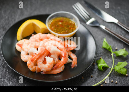 fresh shrimps served on plate with seafood sauce / boiled peeled shrimp prawns cooked in the restaurant Stock Photo