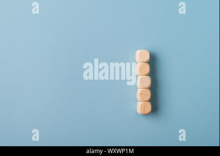 Five blank wooden dices stacked over light blue background with copy space to the left side of the image. Stock Photo
