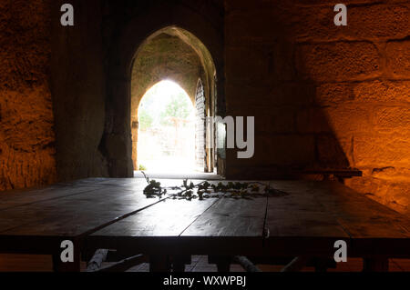 wooden table in dark chamber with light coming from outside Stock Photo