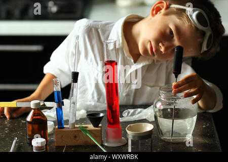 Young scientist chemist surprised while making his scientific experiments. Kids in STEM Stock Photo