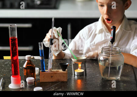 Young scientist chemist surprised while making his scientific experiments. Kids in STEM Stock Photo