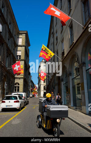 Street in the Old town of Geneva with swiss flags and flags of the Geneva canton, showing the imperial eagle and the key of Saint Peter. Stock Photo