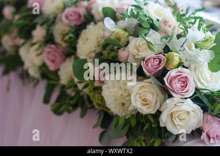Wedding table decoration with pink and white tender roses. Floral decorations design. Selective focus. Stock Photo