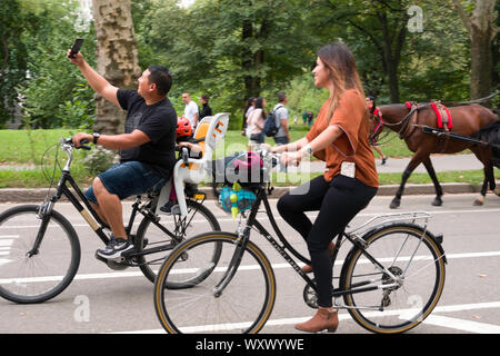 Family Riding Bicycles and Taking Selfies, Central Park, NYC, USA Stock Photo