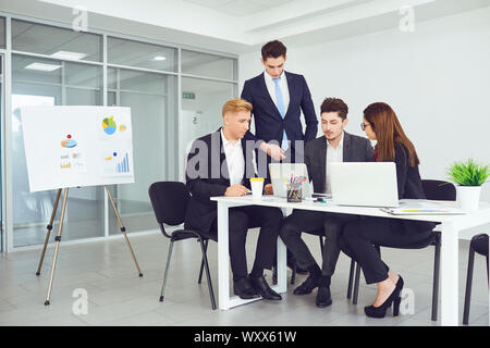 Serious young business people communicate at a table in an office. Stock Photo