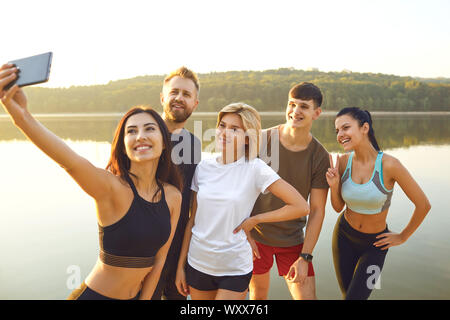 Sports friends taking selfie pictures on the phone in the park. Stock Photo