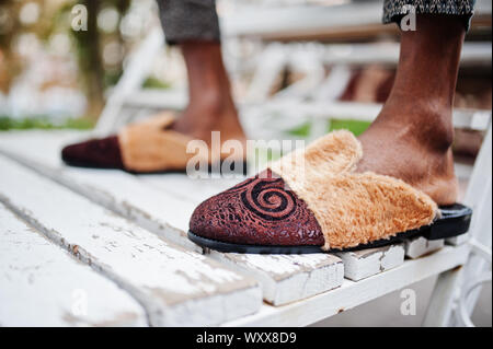 Slippers on the feet of african american man. Stock Photo