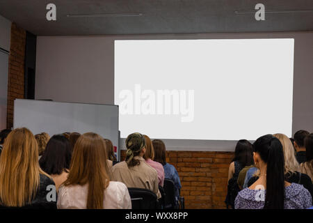 People in auditory during presentation or seminar. Teenagers or young men and women at university lecture or seminar. Back side view with no faces. Th Stock Photo
