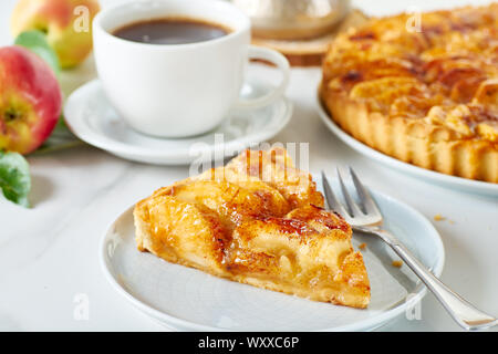 Piece of homemade french apple tart on dish and coffee Stock Photo