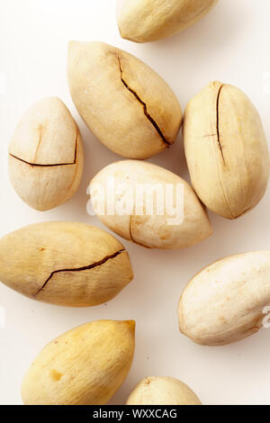 Pecan nuts in nutshells isolated. Overhead image, white background Stock Photo