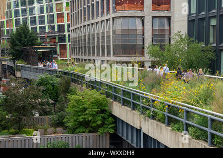 Visitors walk on the High Line in New York City. The High Line is an urban park, nearly 1.5 miles long and several stories high, built on a former ele Stock Photo