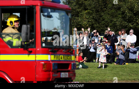 Friends and family wave to recruits during a Dublin Fire Brigade passing-out parade at the Fire Brigade Training Centre in Dublin. Stock Photo