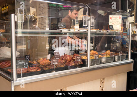 Paris, France - Aug 31, 2019: Man Selliing grilled food in  the  Rue Montorgueil, Market Street in Paris, France. Stock Photo