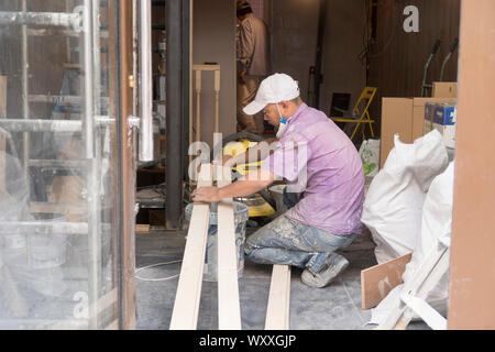 Paris, France - Aug 31, 2019: Two asian men rrenovate the interior of a small shop in Paris, France. Stock Photo