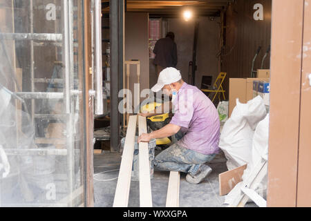 Paris, France - Aug 31, 2019: Two asian men rrenovate the interior of a small shop in Paris, France. Stock Photo