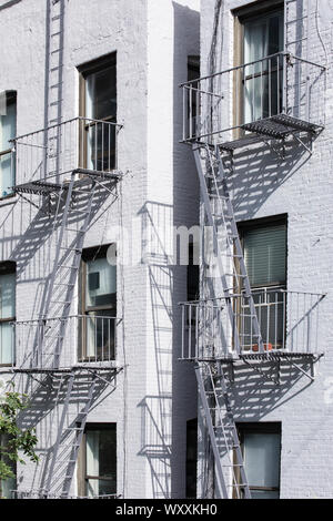 Traditional typical metal fire escape ladder on walk-up brownstone apartment block on west side Manhattan, New York City Stock Photo