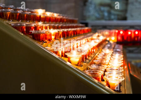 Candles in a church. This type of candles, votive candles, or prayer candles, can be typically bought in a major European church and then lit. Stock Photo