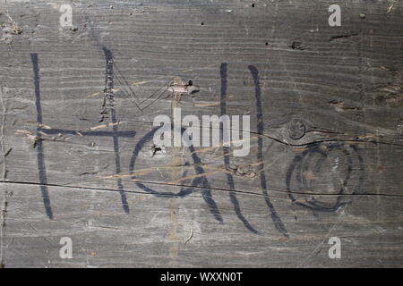 Old weathered wooden tile with hallo written in black on it Stock Photo