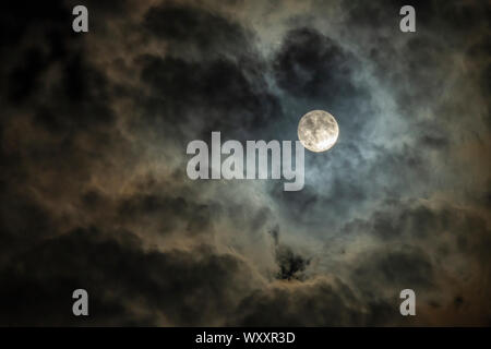 Full moon in cloudy night sky Stock Photo